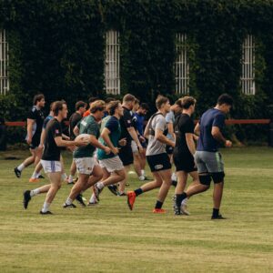 A group of young men practicing rugby on a lush field in Dublin, Ireland.
